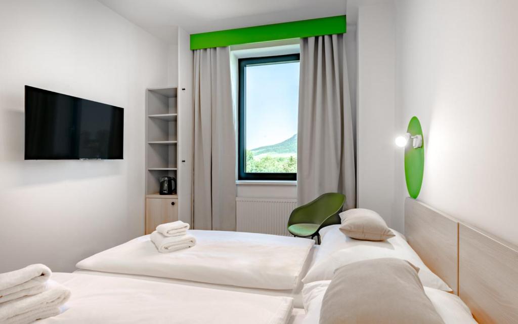 a hotel room with two beds and a television at Hotel Active Stadium in Lovosice