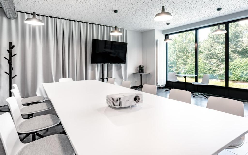 a white conference room with a white table and chairs at Hotel Active Stadium in Lovosice