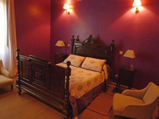 ラ・アドラダにあるPosada Villa Mariaの紫の壁のベッドルーム1室(ベッド1台付)