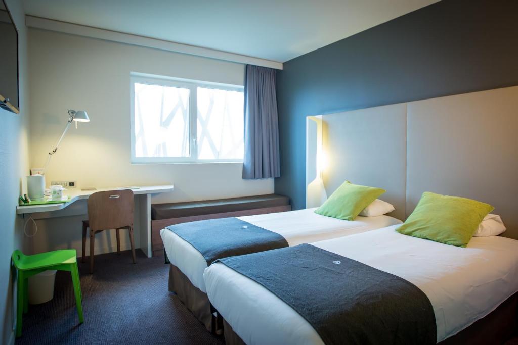 een hotelkamer met 2 bedden en een bureau bij Campanile Dijon Congrès Clemenceau in Dijon