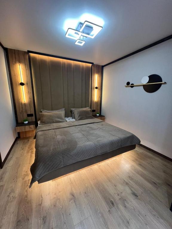 a bedroom with a bed and a light on the wall at Лободы 33 in Karagandy