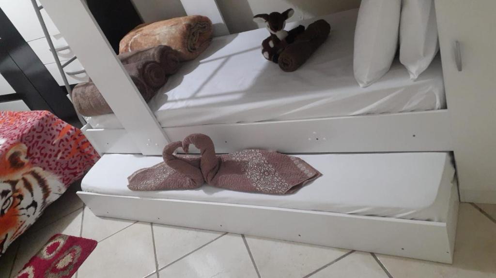 a white shelf with two mens shoes on it at Um apartamento aconchegante in São Lourenço