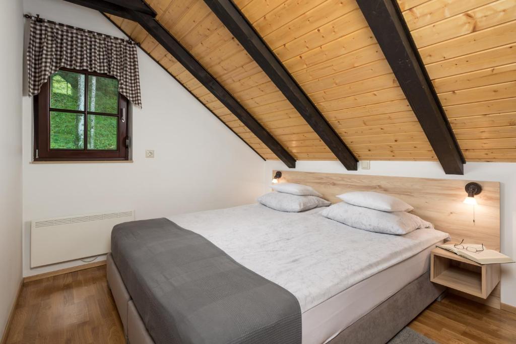 una camera da letto con un letto e un soffitto in legno di Gorska bajka - Jela, kuća za odmor i wellness a Stara Sušica