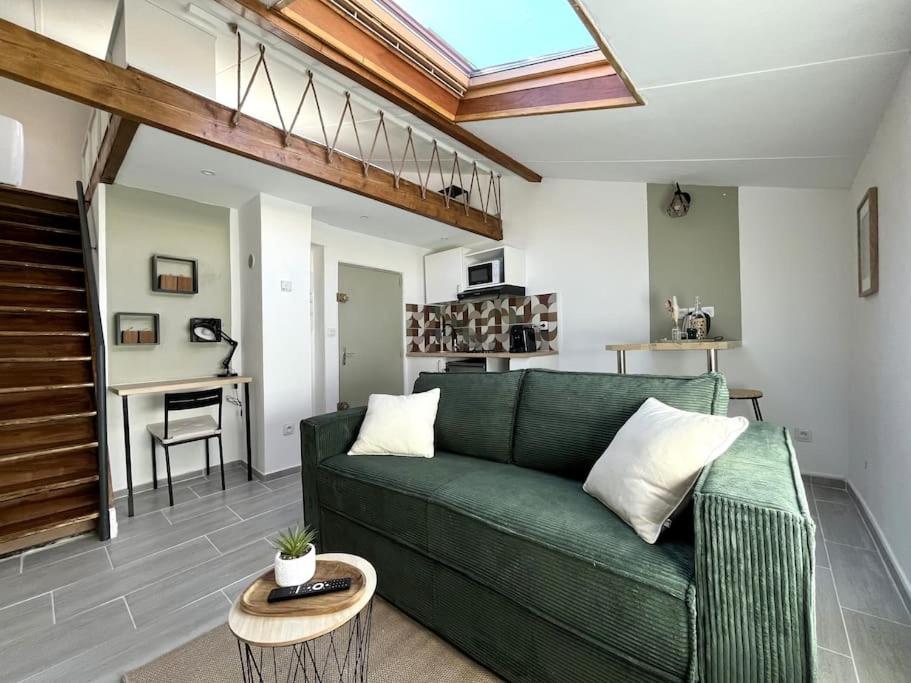 un salon avec un canapé vert et une table dans l'établissement AbriZen Toulouse Hypercentre, à Toulouse