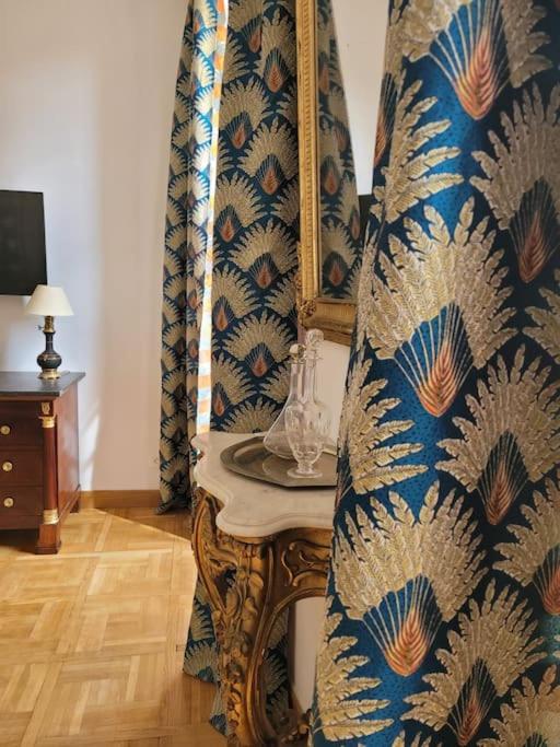 Cette chambre comprend une table avec un rideau bleu et or. dans l'établissement La Livrée des papes, à Châteauneuf-du-Pape