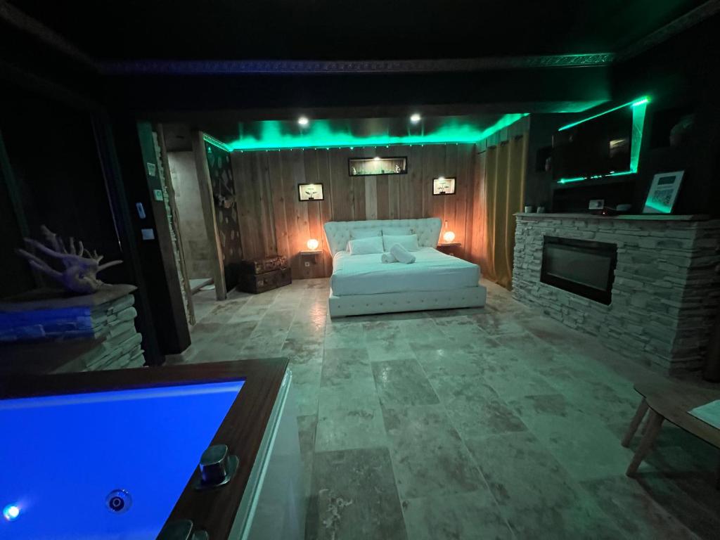 a living room with a white bed and a fireplace at Le Lodge des Charmes 5 étoiles in Lèves