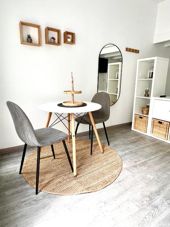 une salle à manger avec une table, des chaises et un miroir dans l'établissement Cocon des Alouettes, à Montmorency