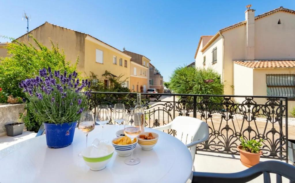 a white table with wine glasses on a balcony at Remarquable T2 avec terrasse in Carqueiranne