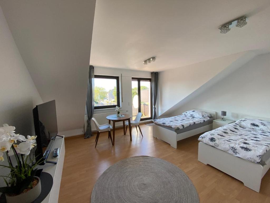un ampio soggiorno con due letti e un tavolo di Am Quellberg Apartments Recklinghausen a Recklinghausen