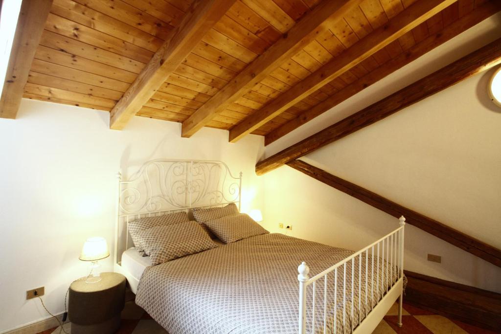 a bedroom with a bed in a room with wooden ceilings at NIDO SUL CERMIS Affittacamere in Varena