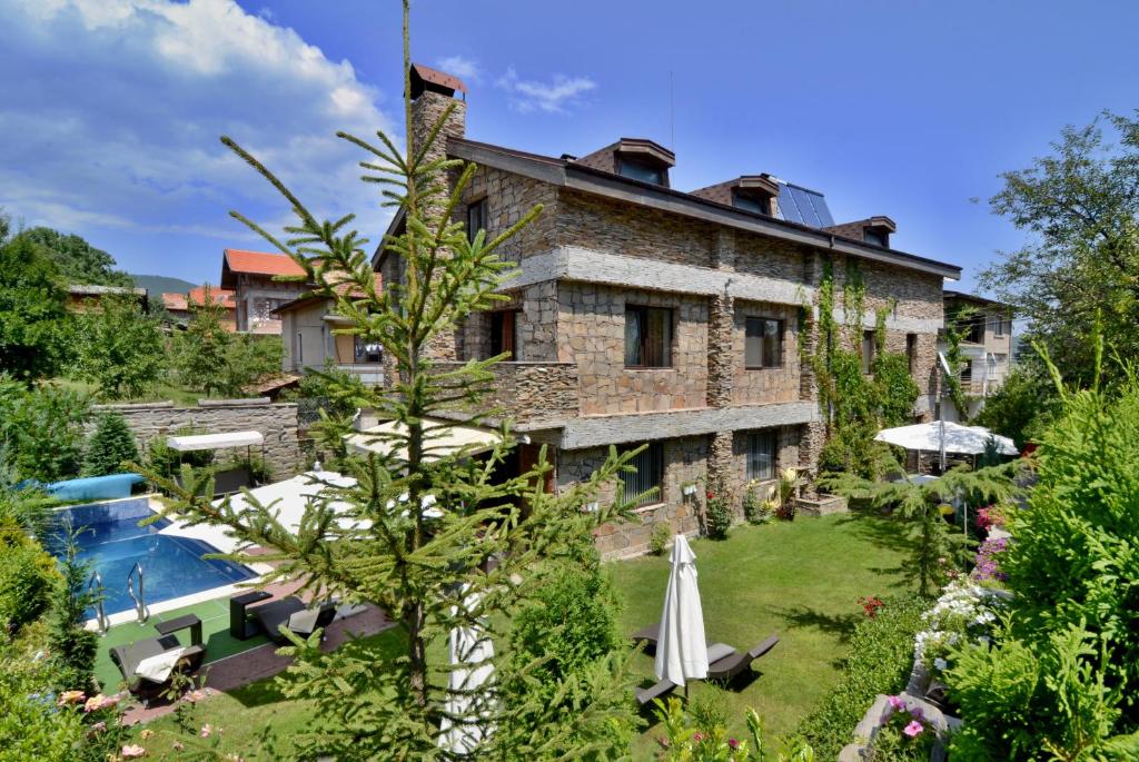um grande edifício de tijolos com um quintal com piscina em Villa Vuchev em Velingrad