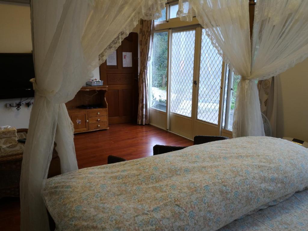 a bedroom with a bed with a canopy at Liang Chen Mei Jin B&amp;B in Shuangxi