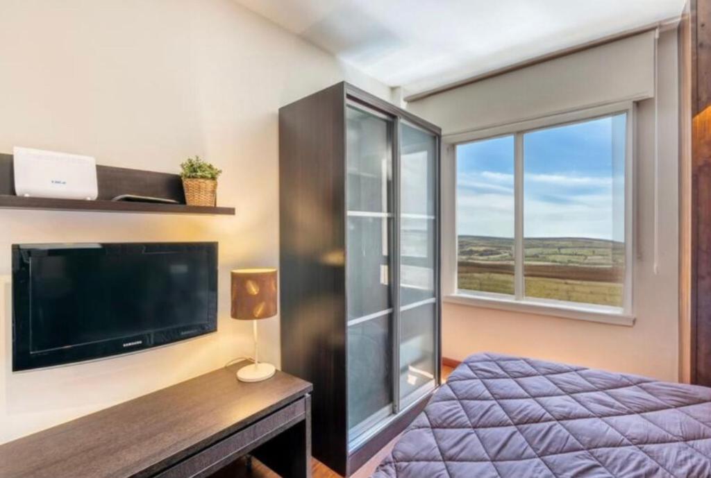 a bedroom with a bed and a large window at Rural-ya Alojamientos Granada Nevada home in La Zubia