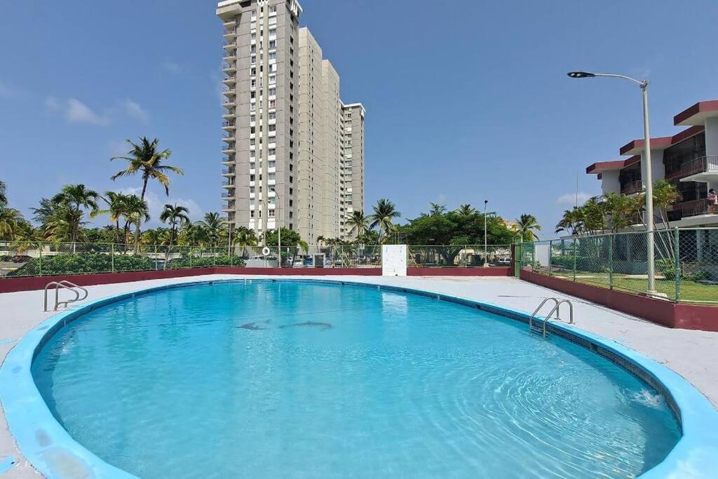 uma grande piscina em frente a um edifício alto em Relaxing Studio Near El Yunque With Pool View em Luquillo