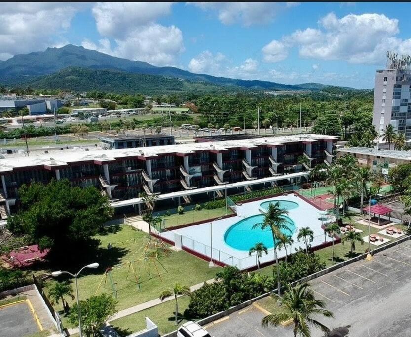 um grande edifício com uma piscina em frente em Relaxing Studio Near El Yunque With Pool View em Luquillo