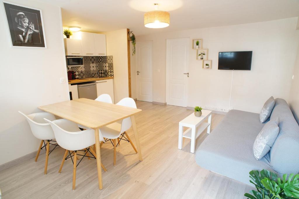 a living room with a table and a couch at Villa Petite Fleur proche Paris CDG Disney Astérix et Parc des Expos in Villeparisis