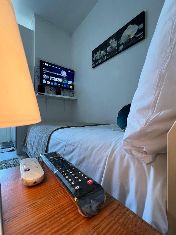 une chambre avec un lit avec une télécommande sur une table dans l'établissement Apartamento Torre Eiffel- Trocadéro, à Paris