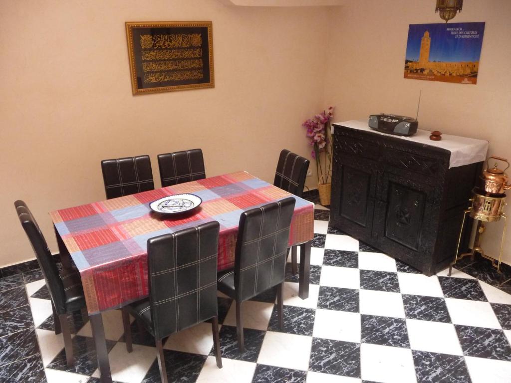 ein Esszimmer mit Tisch und Stühlen und einem Fernseher in der Unterkunft RYAD Pierre in Marrakesch