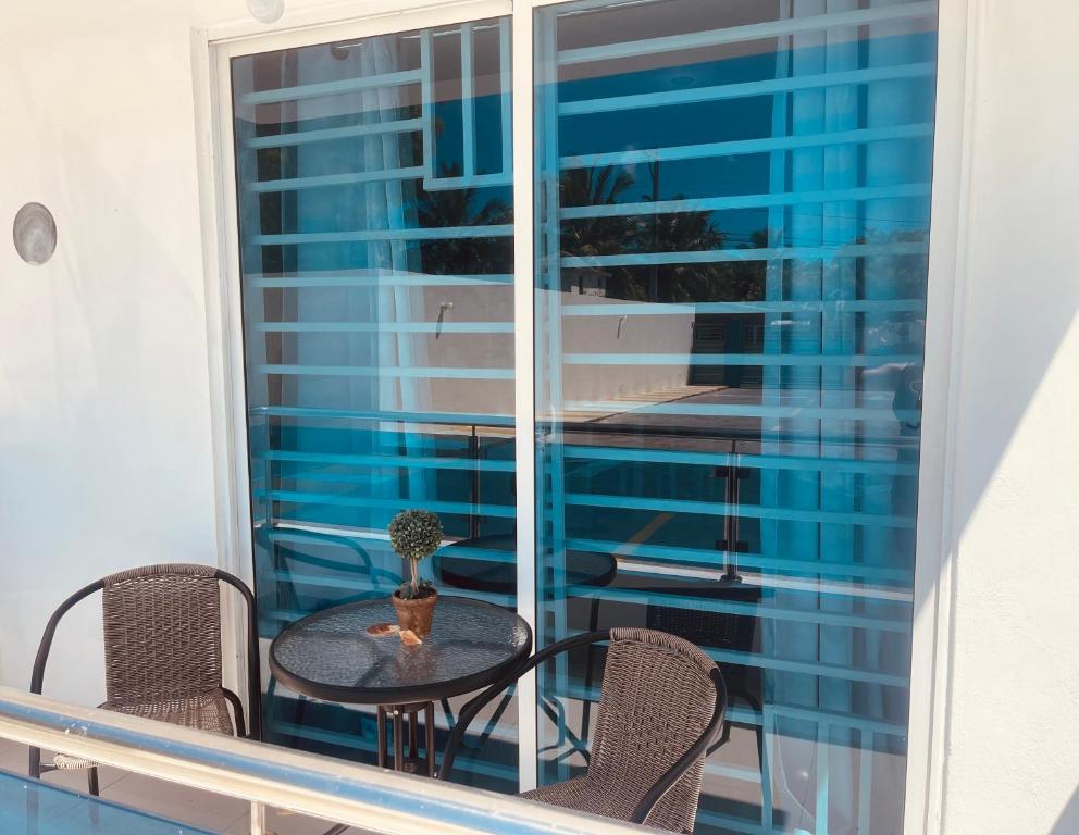 ein Tisch und Stühle auf einem Balkon mit Fenster in der Unterkunft A Caribbean-style rebirth, 2 minutes from the beach in La Romana