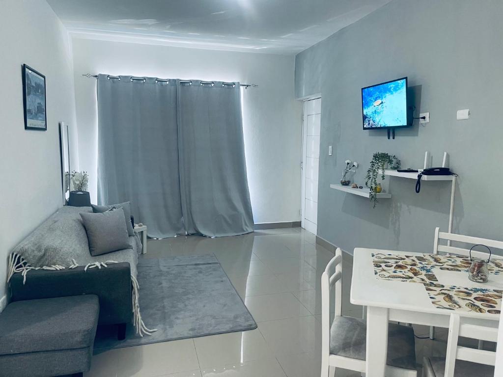 Una sala de estar con una mesa y un comedor. en Caribbean style POOL walking distance free, en La Romana