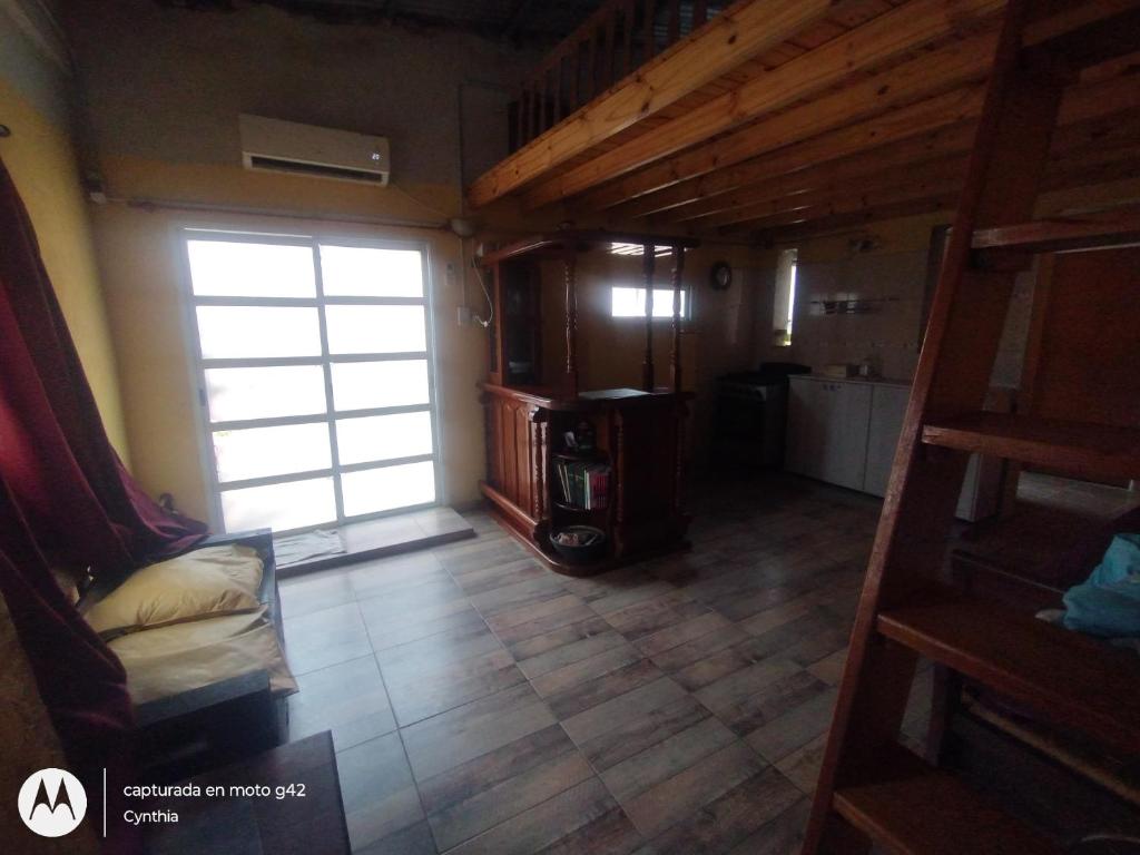 a living room with a stairs leading to a room with a window at Alborada Hostel in Resistencia