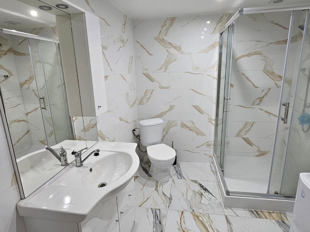 a bathroom with a sink and a toilet and a shower at Izba v apartmáne in Šaca