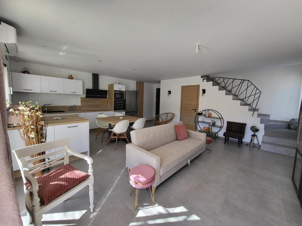 Il comprend un salon avec un canapé, une cuisine et un escalier. dans l'établissement Mas du Magaou Pres de Marseille, Cassis, Aix-en-Provence, à Auriol