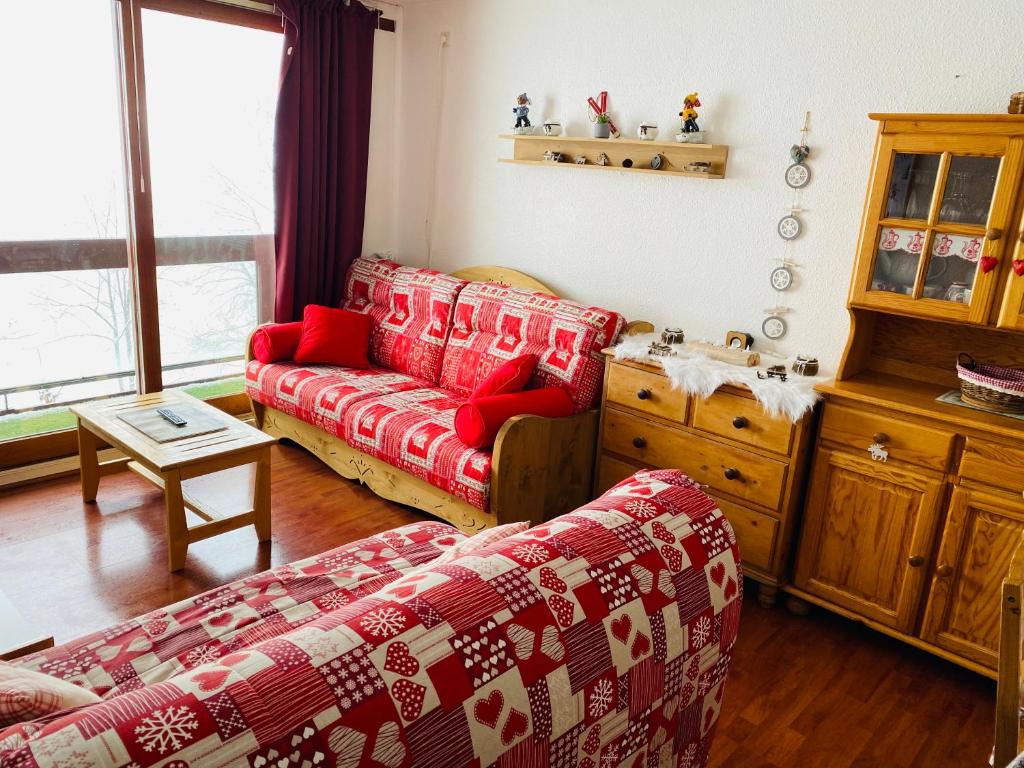 un salon avec un canapé rouge et une table dans l'établissement La montagnarde, à Villarembert