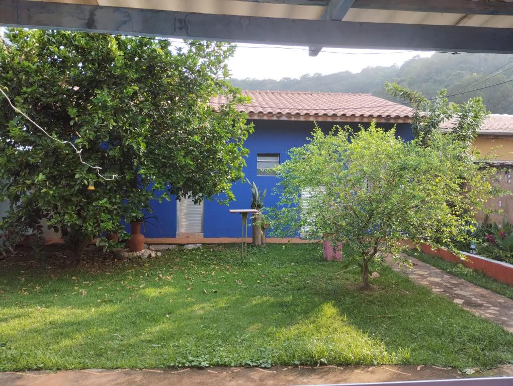 a blue house with trees in front of it at Cantinho do sossego edícula Massaguaçu in Massaguassu
