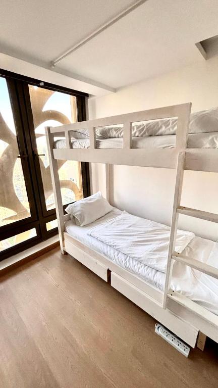 ein Zimmer mit zwei Etagenbetten und einem Fenster in der Unterkunft Ora Place JBR in Dubai