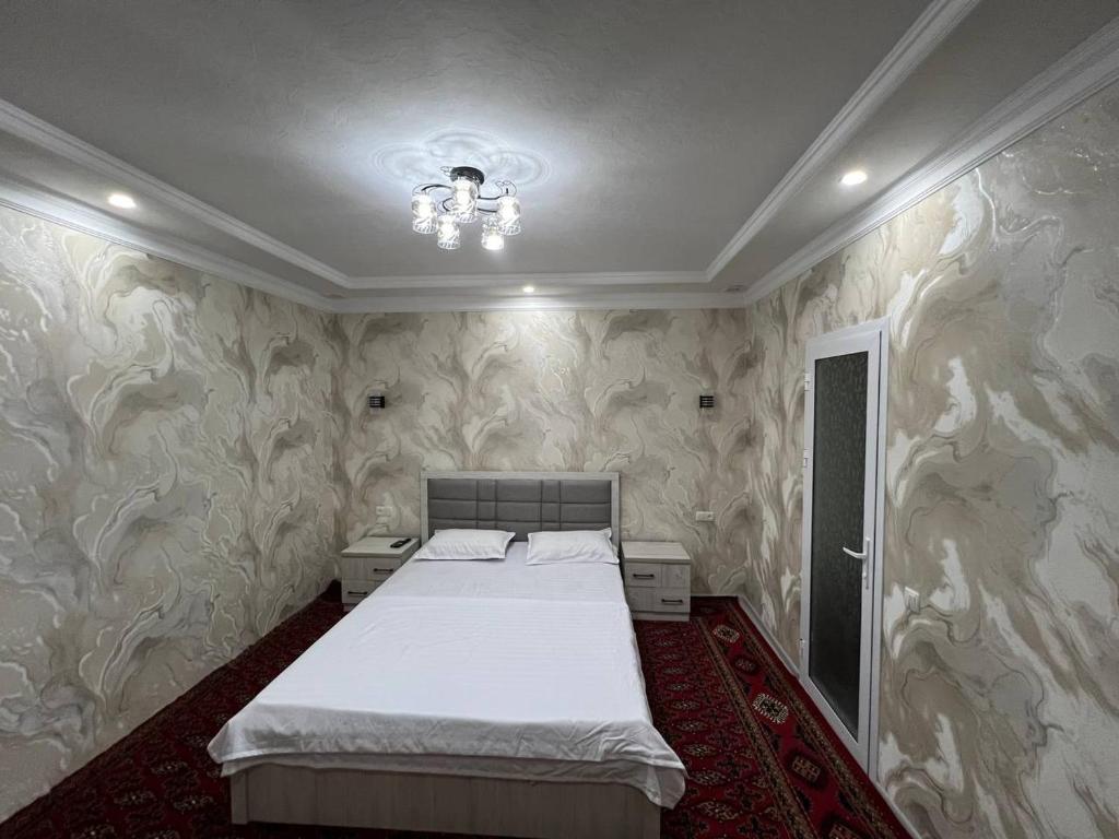 1 dormitorio con 1 cama en una habitación con papel pintado en Islam guest house, en Samarkand