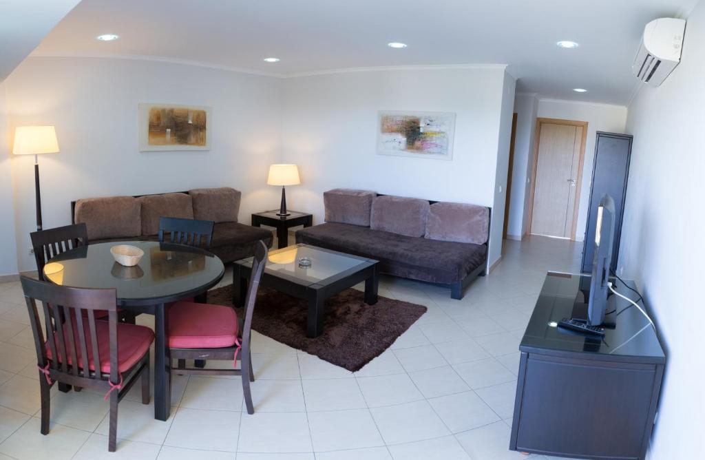 a living room with a couch and a table at Parque Mourabel, Oásis Village & Pé do Lago in Vilamoura