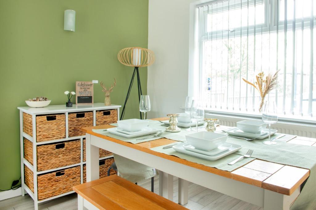 a dining room with a table with dishes on it at 3 bed home in Wollaton, Nottingham in Chilwell