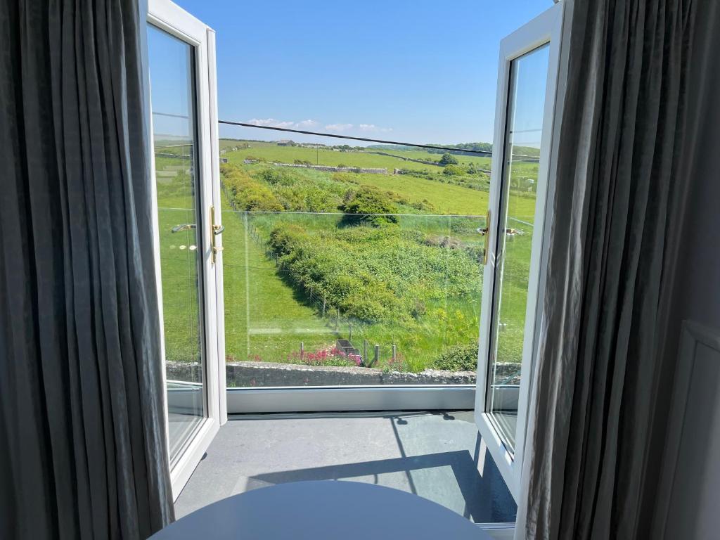 a room with a large window with a view at Woodlands Coastal Apartment in Southerndown