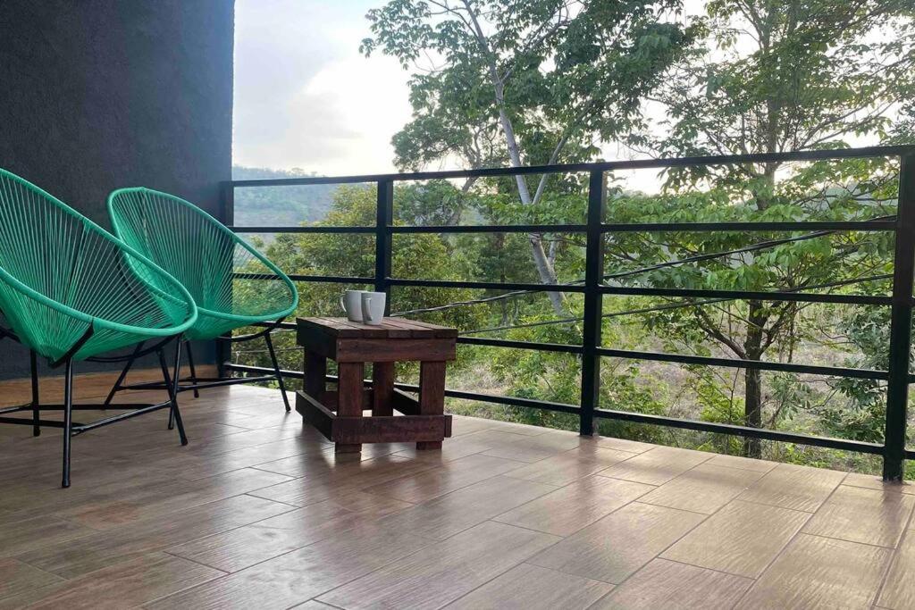 ein Balkon mit zwei Stühlen und einem Tisch und einem Fenster in der Unterkunft Apartment Casa Melodia in Chirilagua