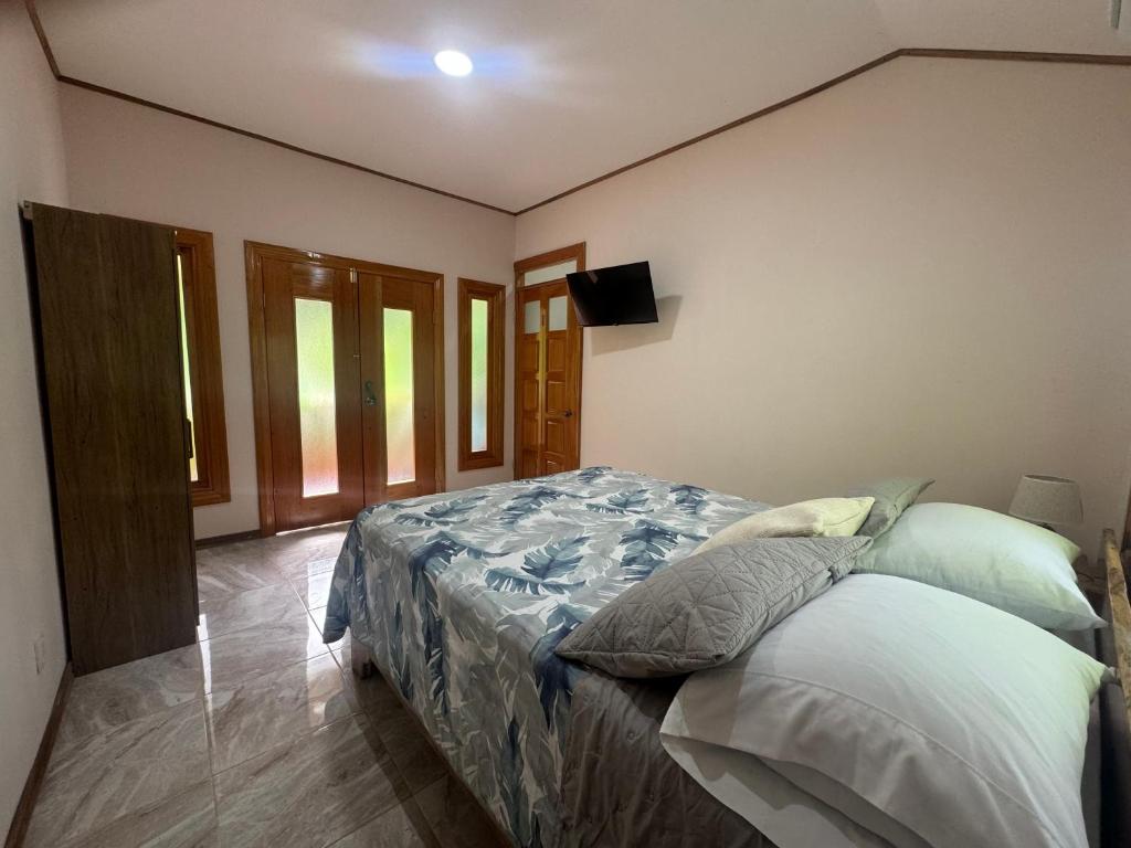 a bedroom with a bed and a flat screen tv at Chilamate Room 2 in Tortuguero