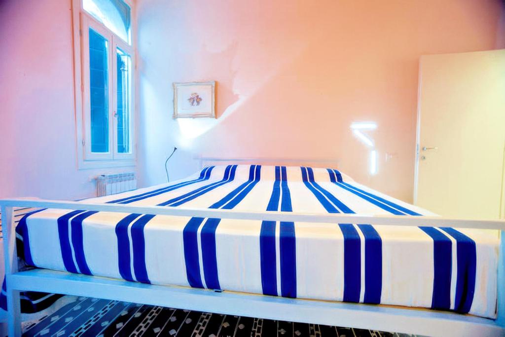 uma cama com um colchão listrado azul e branco em Ca' Vittoria em Veneza