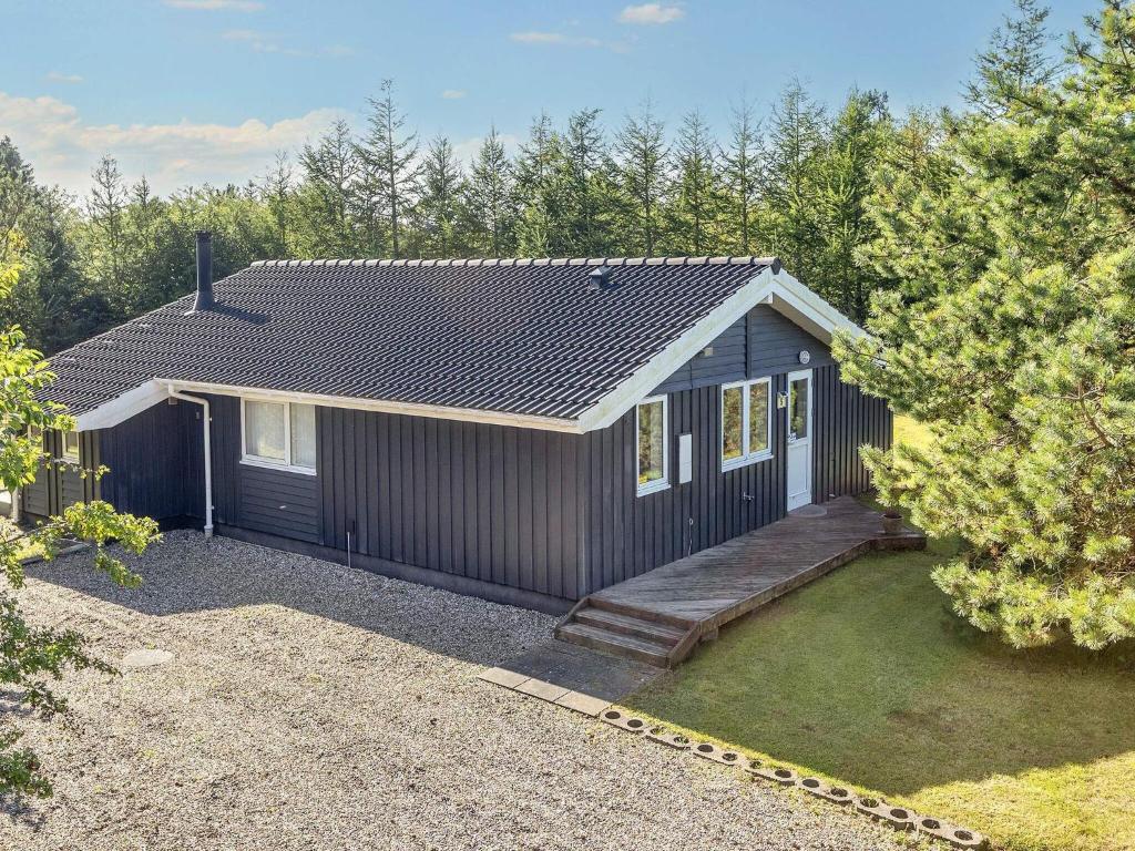 een klein zwart huis met een veranda bij Family Beach Retreat - By Traum Ferienwohnungen in Løgstør