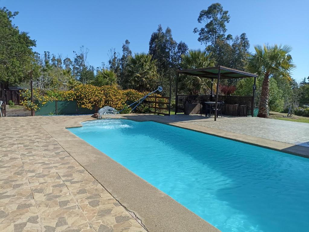 a swimming pool with a slide in a yard at Cabañas La Querencia de Algarrobo in Algarrobo