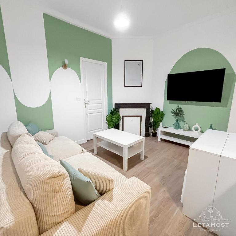 un salon avec un canapé et une télévision dans l'établissement L'Émeraude Urbaine, à Villeneuve-Saint-Georges