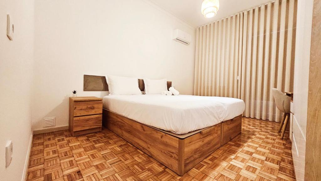 a bedroom with a large bed and a wooden floor at Rooms4you 3 in historic center of Braga in Braga