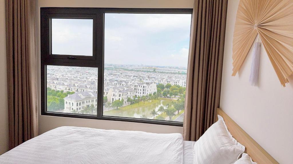 - une chambre avec une grande fenêtre donnant sur la ville dans l'établissement AnChi Home - Garden view- Căn hộ 2 giường đẹp - Ocean Park Gia Lâm, à Hanoï