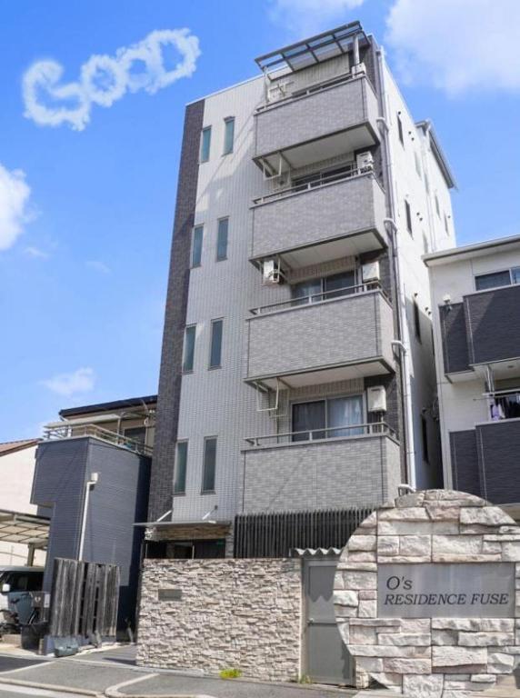 a tall apartment building with a sign in front of it at F HOUSE Os Residence D3 in Osaka