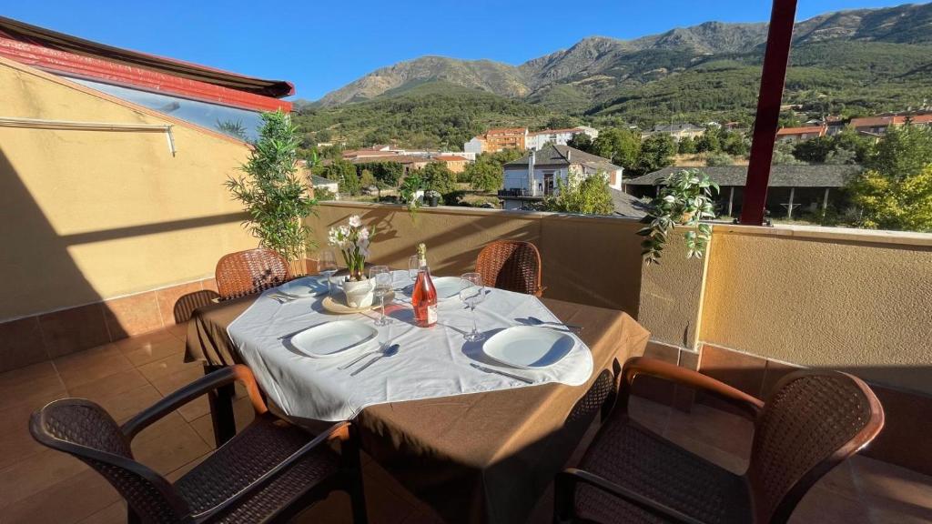 a table on a balcony with a view of mountains at El Mirador de Hervas in Hervás