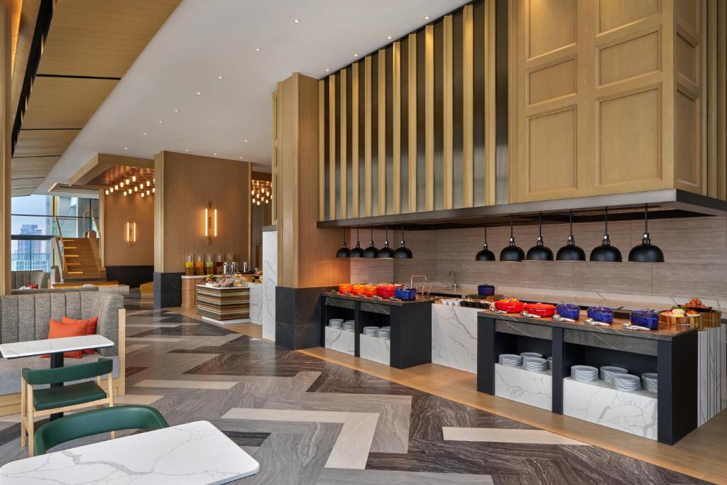 A polished buffet counter set within a spacious hotel dining area.