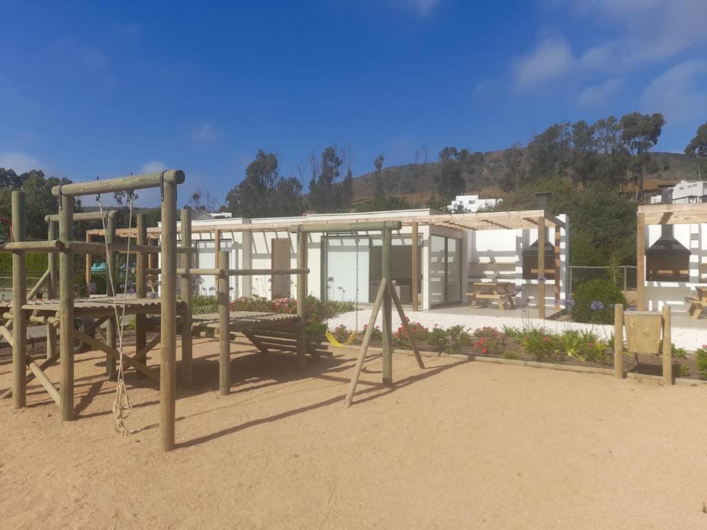 a park with a swing set and a building at Punta Puyai Full equipo a pasos del mar in Papudo