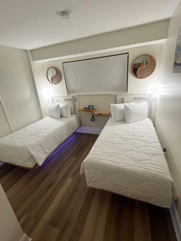 Kleines Zimmer mit 2 Betten und einem Bildschirm in der Unterkunft Luxe by the Sea - 5-Star Beachfront Escape in Myrtle Beach
