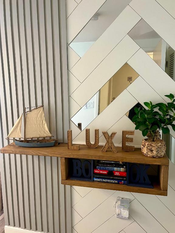 ein Holzregal mit einem Spiegel und Büchern in der Unterkunft Luxe by the Sea - 5-Star Beachfront Escape in Myrtle Beach