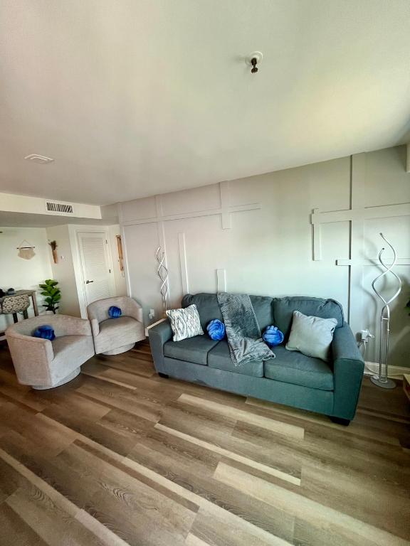 ein Wohnzimmer mit einem blauen Sofa und Holzböden in der Unterkunft Luxe by the Sea - 5-Star Beachfront Escape in Myrtle Beach