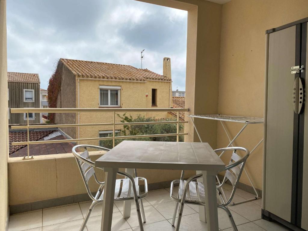 une table et des chaises sur un balcon avec vue dans l'établissement T2 avec terrasse, cuisine équipée, clim & wifi, proche Thermes - FR-1-553-277, à Balaruc-les-Bains